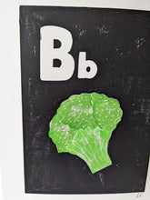 Load image into Gallery viewer, A close up of a black and white print with a green broccoli printed on it
