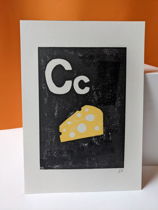 A black and yellow print of a block of cheese and the letter C against on orange background