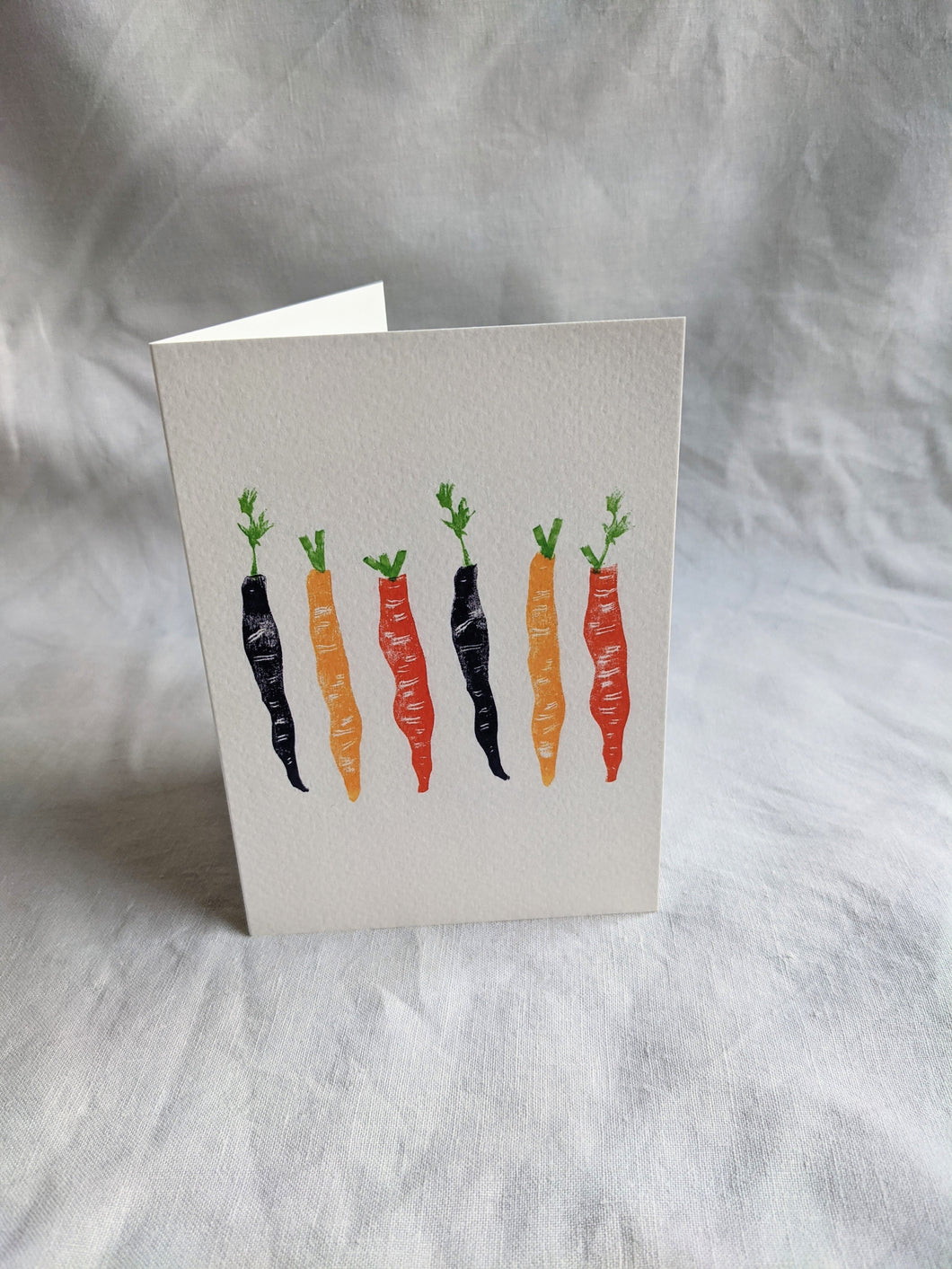 A white card with colourful carrots printed on the front