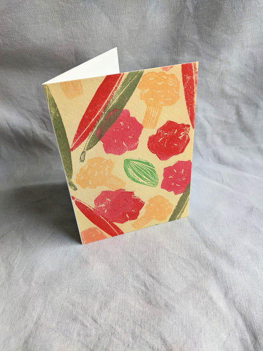 A white card with colourful pickles printed on the front