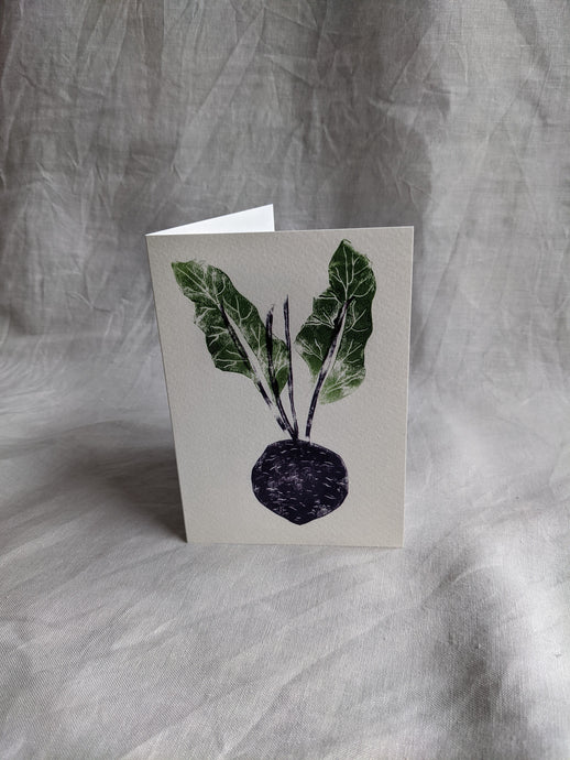 A white card printed with a purple beetroot and two green leaves