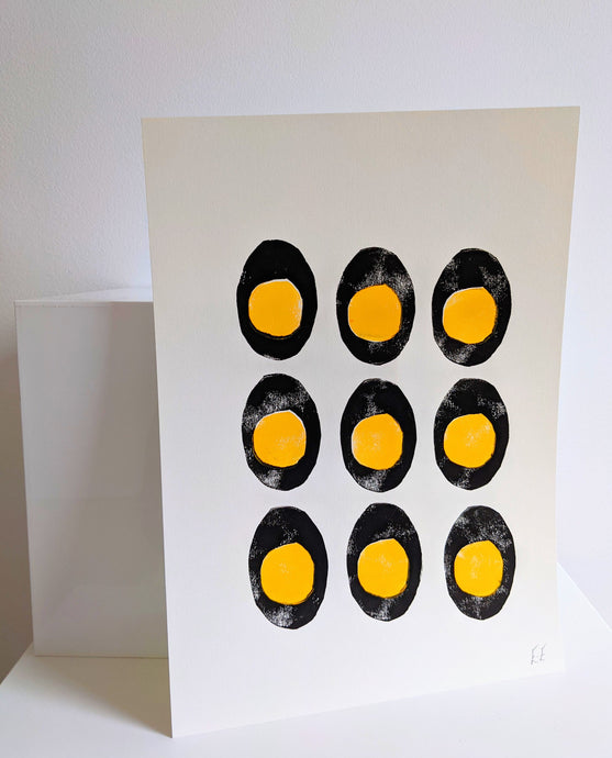 A white print with 9 black and yellow boiled eggs printed on