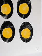 Load image into Gallery viewer, A white print with a close up of four black and yellow boiled eggs
