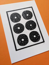 Load image into Gallery viewer, A black and white print of six sesame bagels against an orange background
