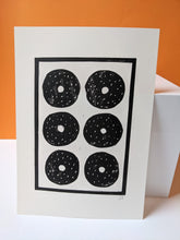 Load image into Gallery viewer, A black and white print of six sesame bagels against an orange background

