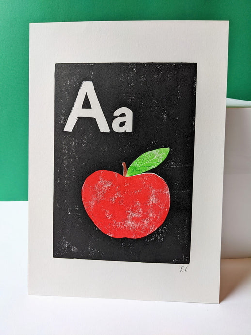 A black, white and red print of an apple with the letter A on it
