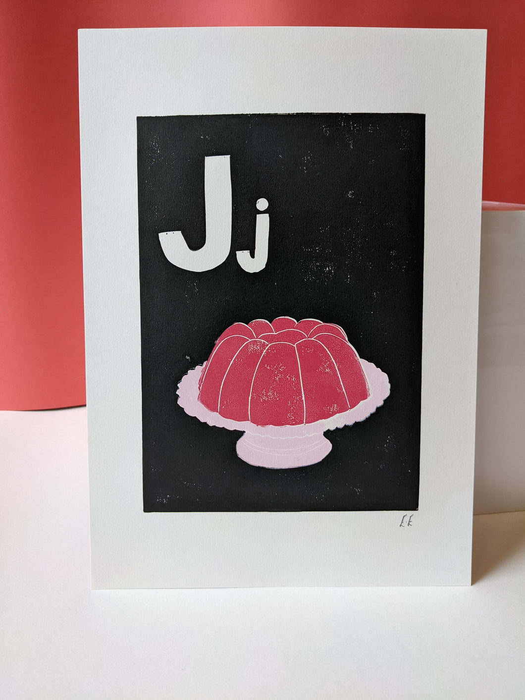 A black print with a pink jelly printed on it and the letter J