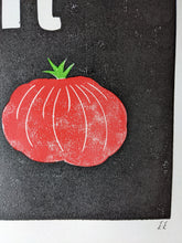 Load image into Gallery viewer, A black print with a red tomato and the letter T carved out of it in white
