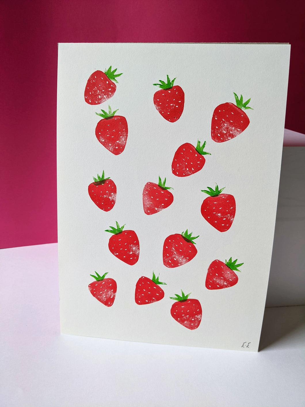 A white print with red strawberries printed on it