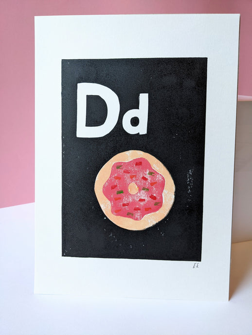 A black and white print with a pink sprinkle doughnut printed on it